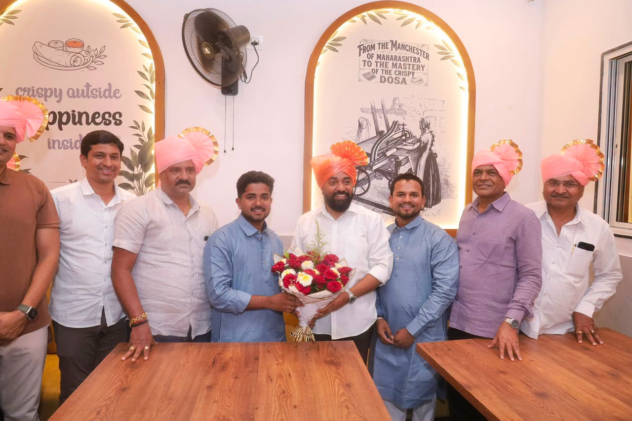 Rahul Awade at an establishment in Ichalkaranji, beside wall artwork describing the city as the Manchester of Maharashtra.