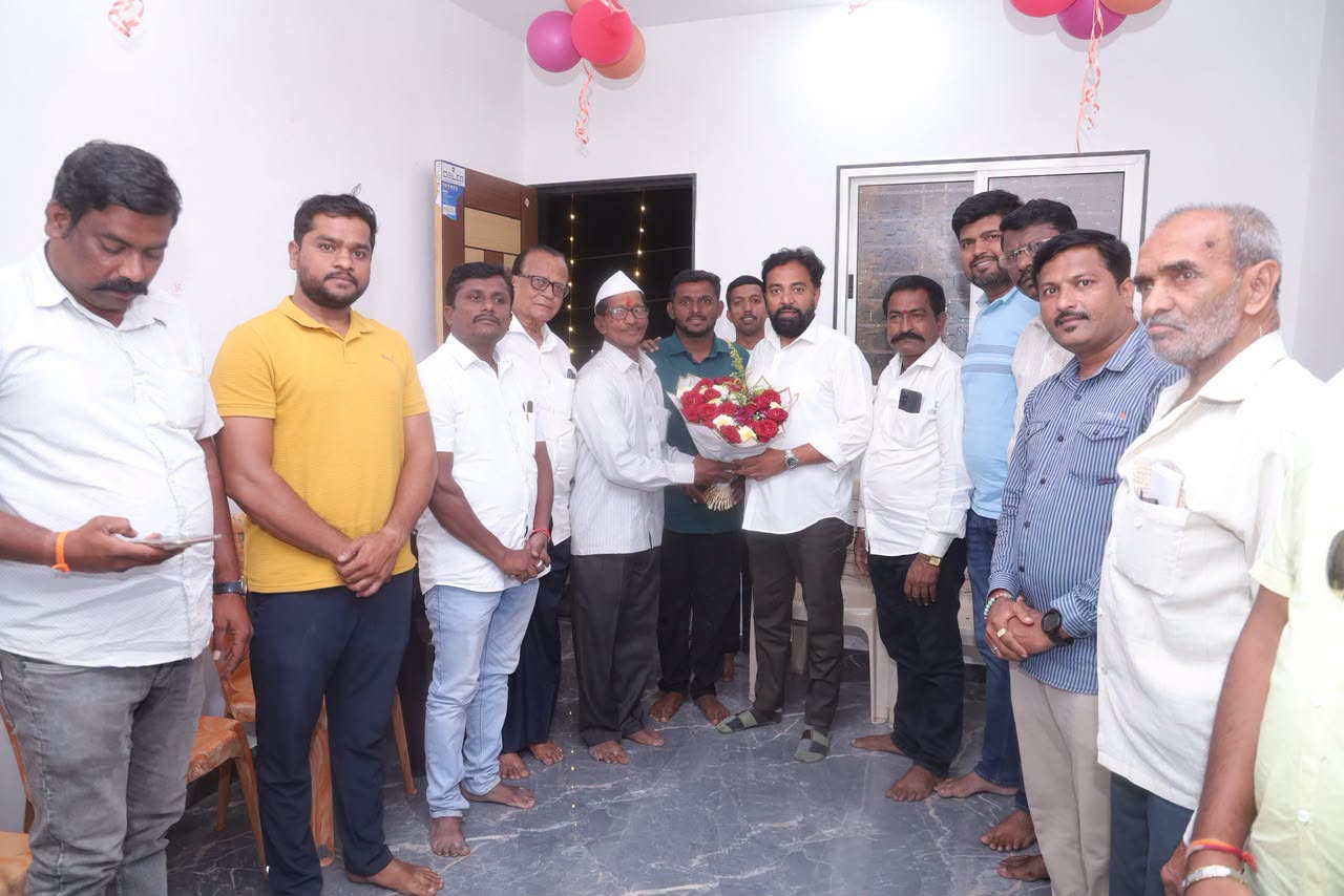 Rahul Awade presenting a bouquet to an elderly resident at a gathering in a home in the Ichalkaranji constituency.