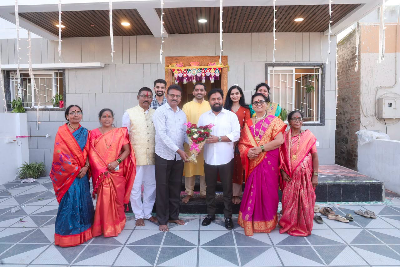 Rahul Awade in a group photograph with residents outside a newly built home in the Ichalkaranji constituency.