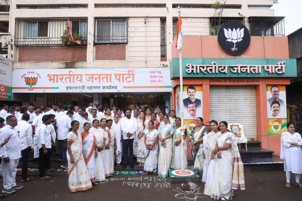 Flag hoisting outside the Bharatiya Janata Party office in Ichalkaranji, with Rahul Awade and a large gathering of party workers and residents.
