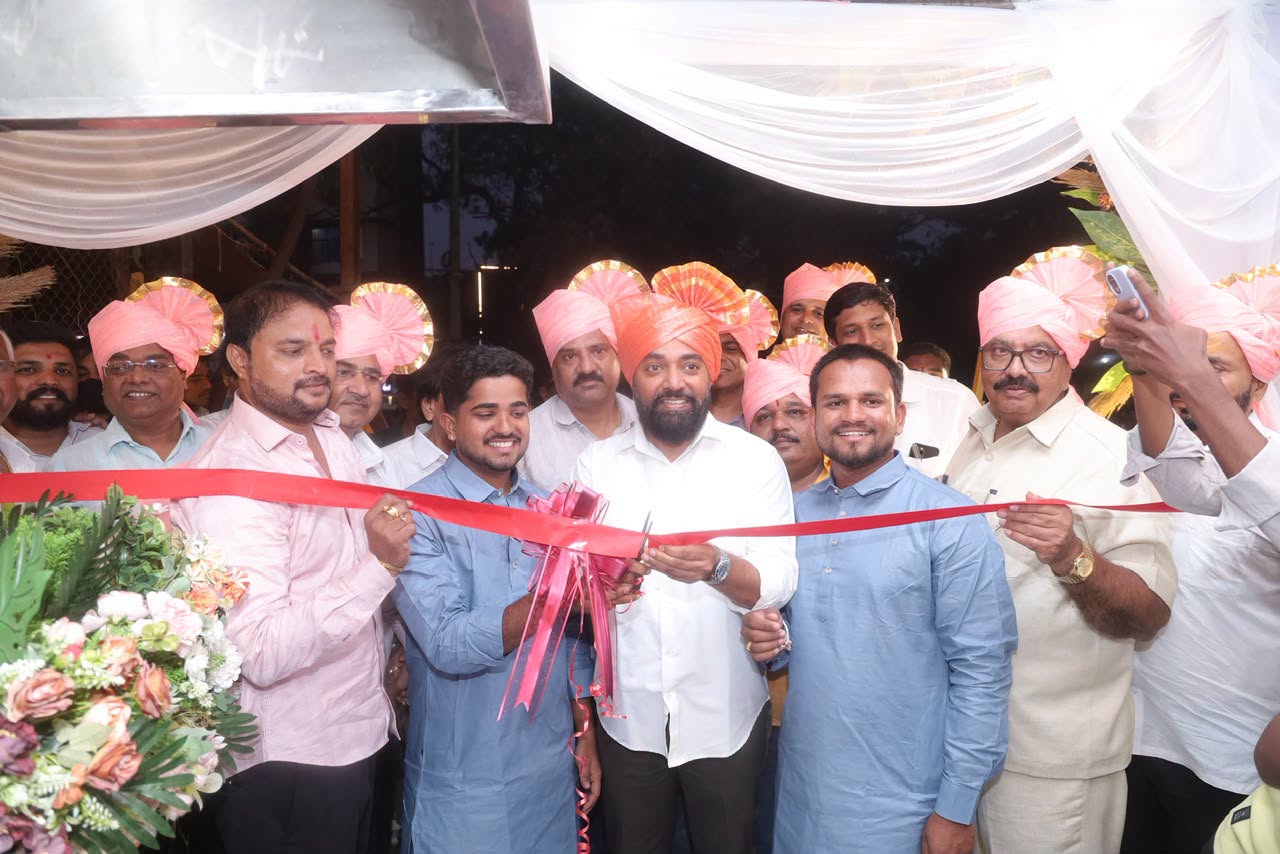 Rahul Awade cutting a ribbon at an evening inauguration in Ichalkaranji, surrounded by residents wearing ceremonial phetas.