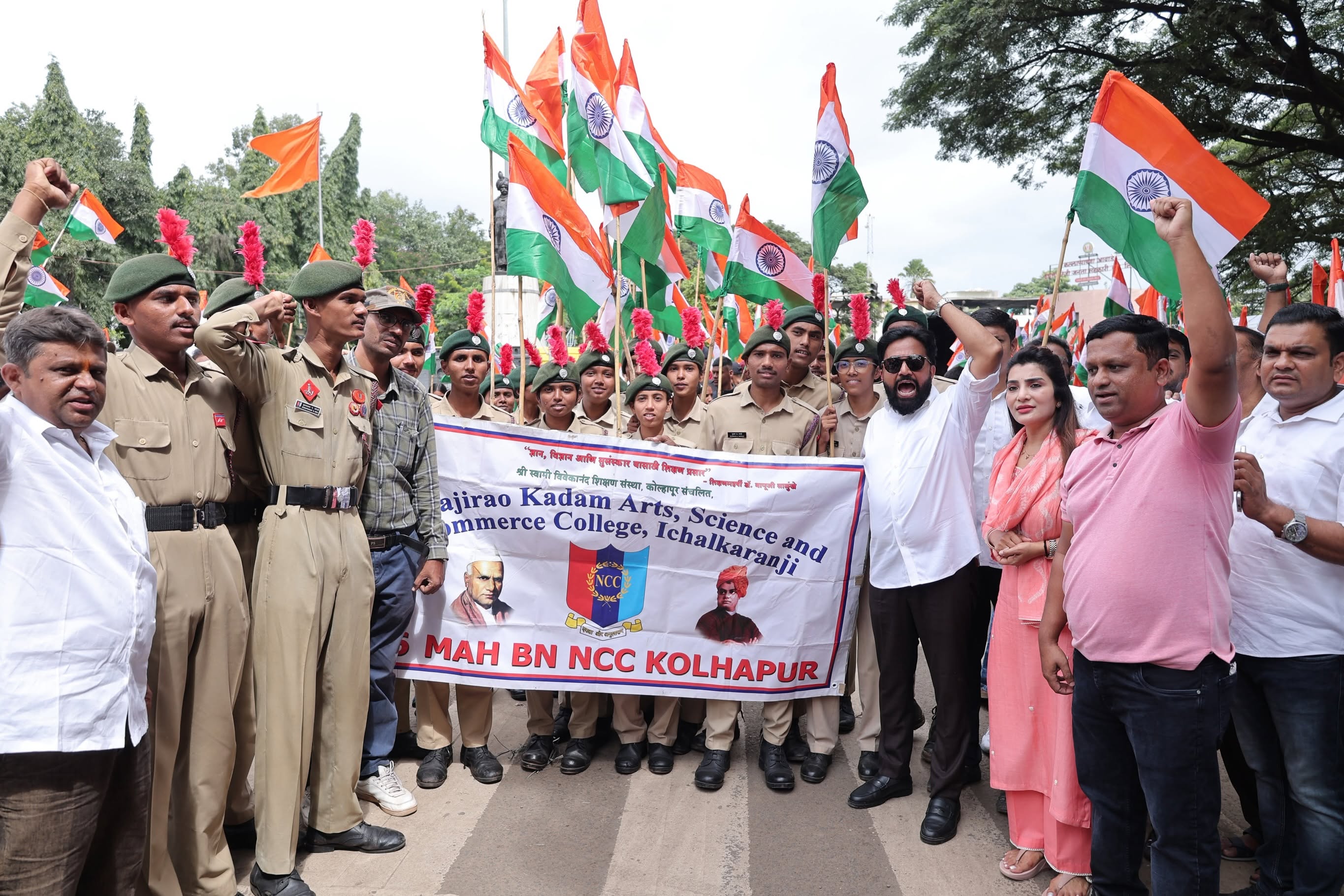 Rahul Awade with NCC cadets and residents at a tiranga rally in Ichalkaranji, with a banner of a local arts, science and commerce college.