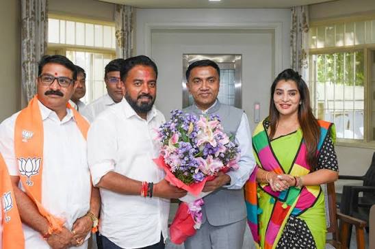 Rahul Awade presenting a bouquet during a courtesy call at a party programme, with colleagues present.